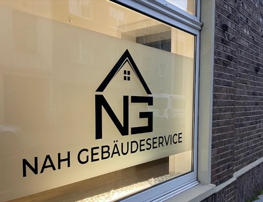 Nahaufnahme der Fensterbeschriftung am Büro von Nah Gebäudeservice in Neuss, die das professionelle Markenlogo und den Firmennamen auf der Glasfront zeigt.